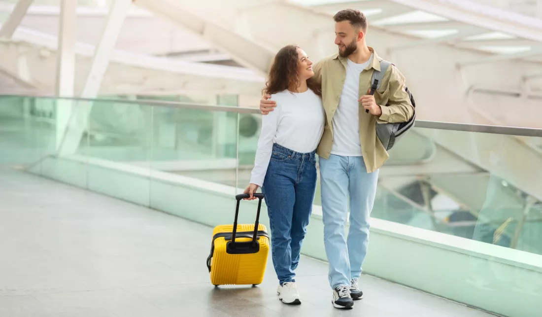 Mloda para z bagazem idzie przez terminal lotniska